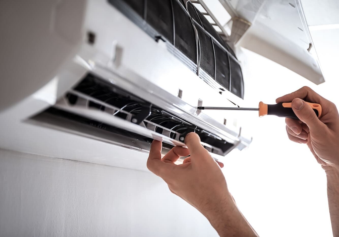 Electrician repairing air conditioner indoors Electrician repairing air conditioner indoors